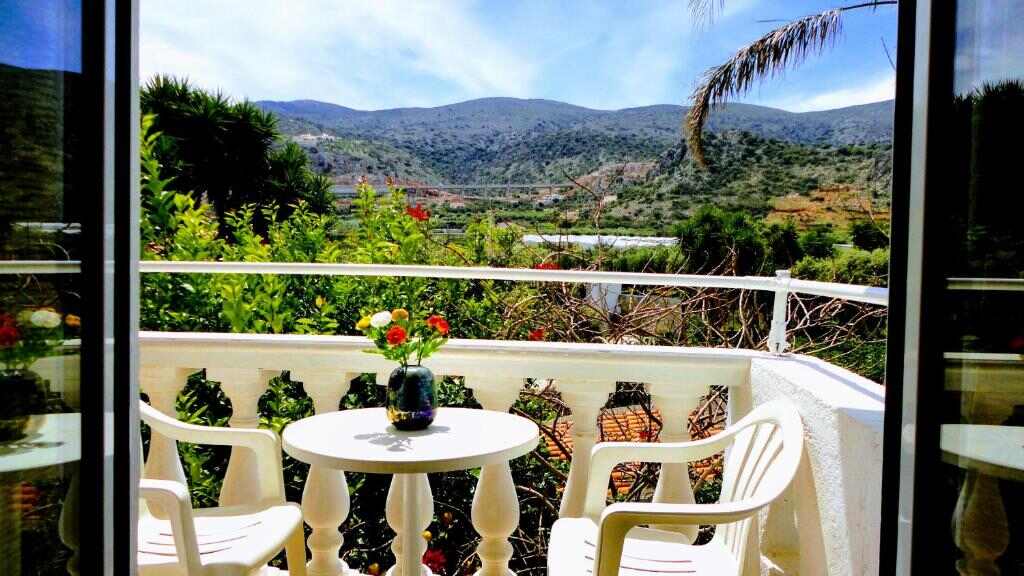 Balcony with table and chairs overlooking the Cretan hills